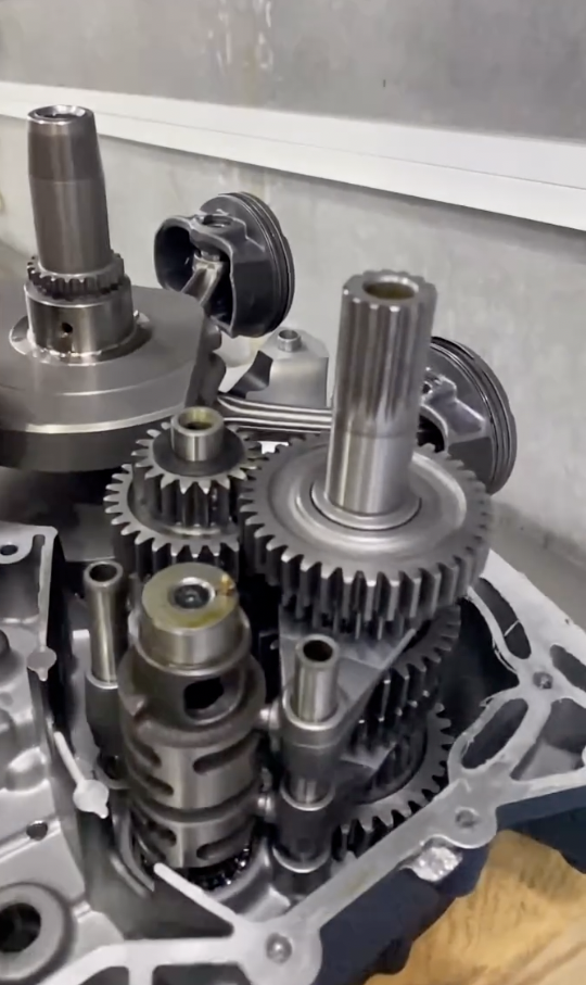 Inside of a Harley-Davidson engine case showing gears, pistons and camshafts
